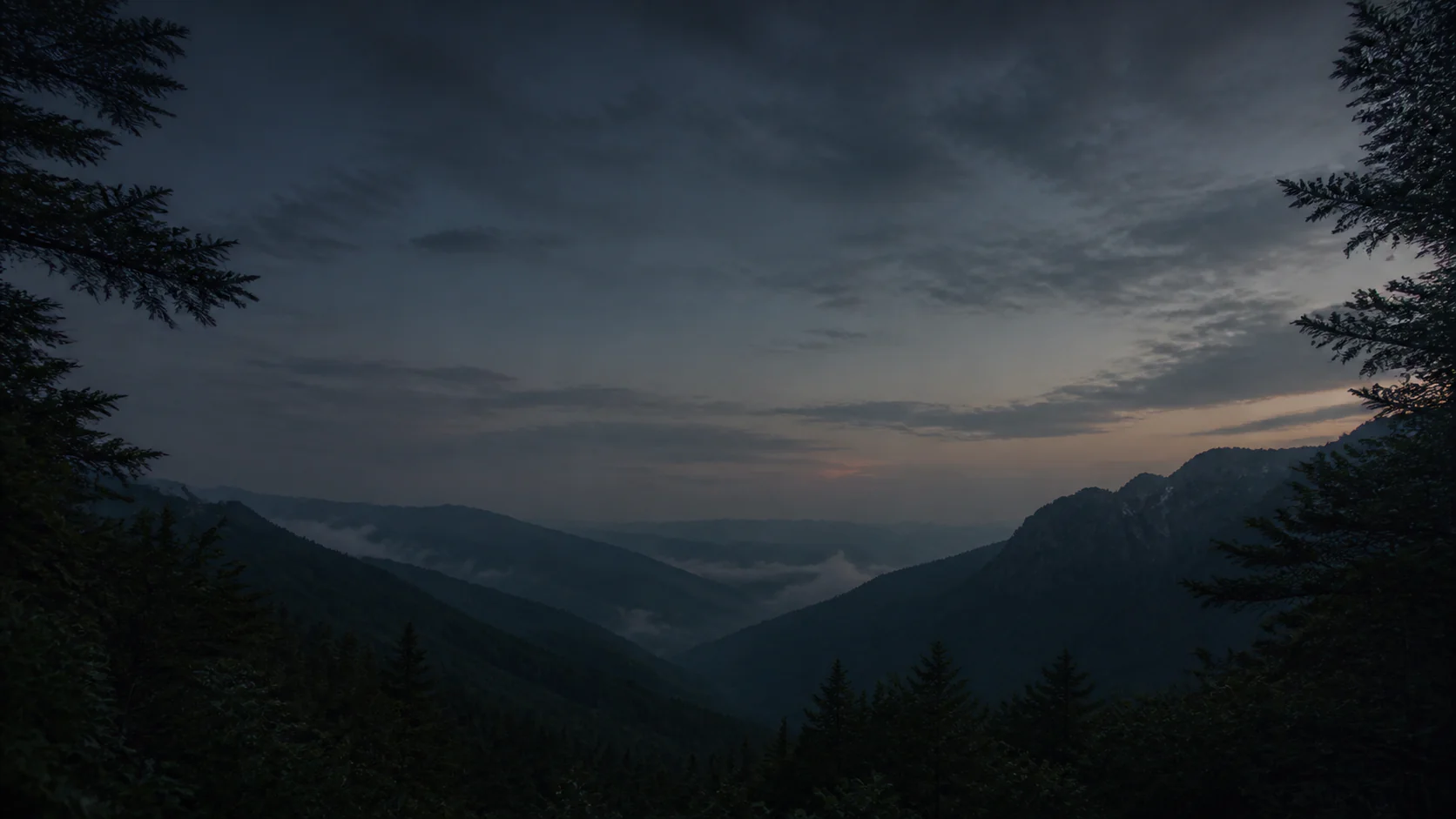 Layered mountains and forest at dusk